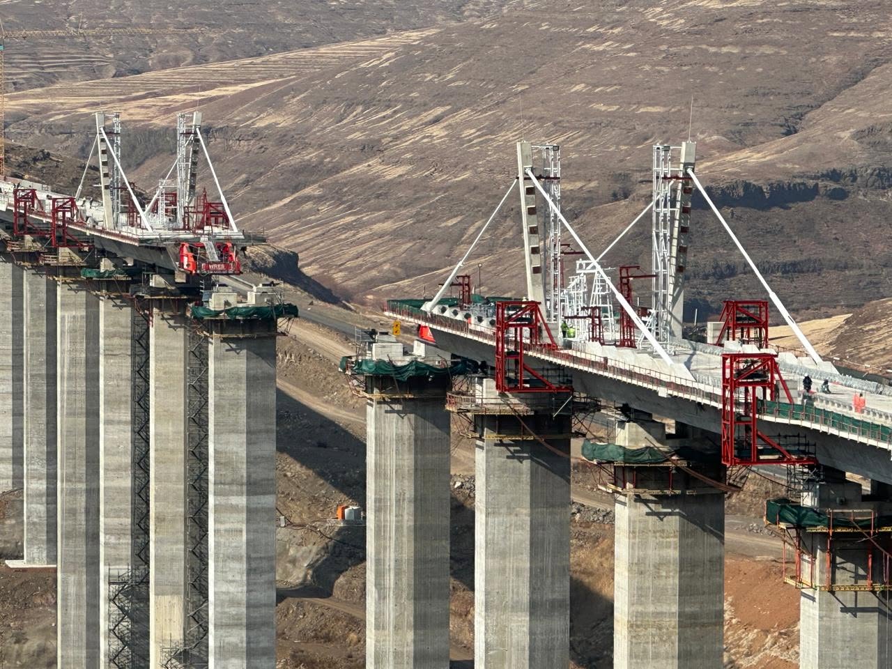 Bridge deck segments and launching gantries on tall concrete piers at Senqu Bridge