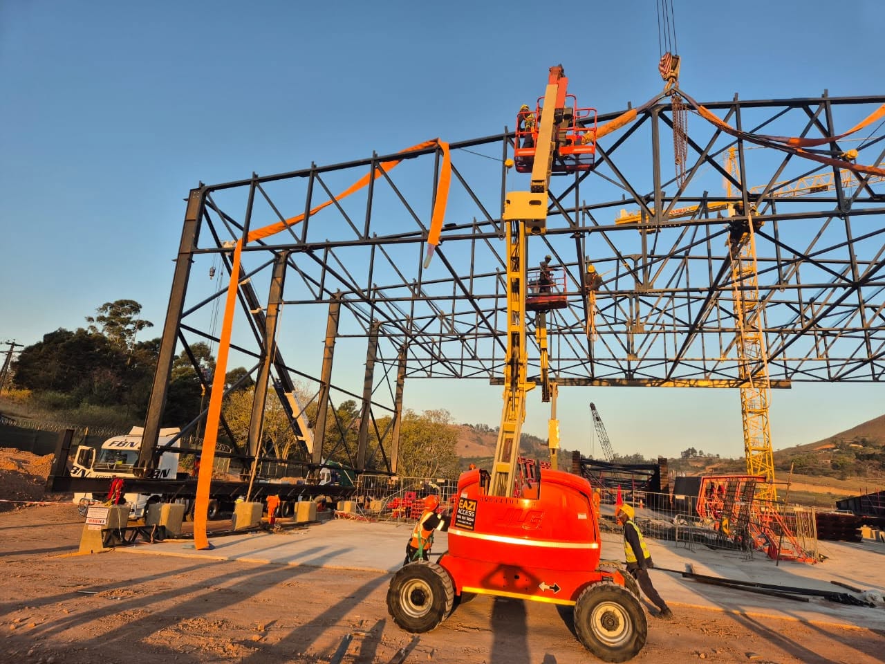 Site team erecting steel trusses with a cherry picker at Key Ridge